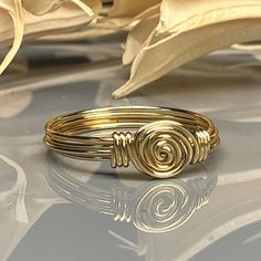 "Handmade Dainty Swirl Sterling Silver, Yellow or Rose Gold Filled Wire Wire Wrapped Ring; Custom Made to Size Indulge in the beauty and intricacy of this Wire Wrapped Rosette Swirl Ring. Handcrafted with care, this stunning ring features a unique and eye-catching design that is sure to turn heads. Crafted from your choice of sterling silver, 14k yellow or rose gold filled wire, this ring showcases the beauty and durability of precious metals. The wire is intricately wrapped in a swirl pattern, Adjustable Spiral Yellow Gold Ring, Twisted Gold Ring For Gift, Spiral 14k Gold Ring, 14k Gold Spiral Rings, Gold Spiral Ring With A Modern Twist, Spiral Rose Gold Jewelry For Anniversary, Gold Spiral Wedding Ring, 14k Gold Wire-wrapped Rings, Wire Wrapped 14k Gold Rings