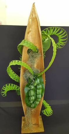 a wooden sculpture with green plants in it