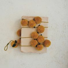 small orange pom poms tied to a piece of paper on a white surface