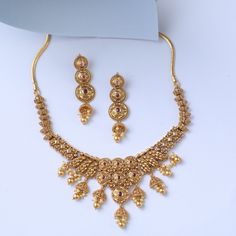 Description Inspired by the shimmering Indian gold jewelry. This Collection is designed to highlight fine Indian craftsmanship. It is crafted in gold-plated 925 silver with intricate textures and tones. Modern designs adorn you with timeless floral patterns. This jewelry is perfect for wedding and festival events. Brimming with festive elegance, the Jhumki Silver Necklace Set is a timeless piece. The design features jhumki charms all around, shining with pearl drops and pink stones. Suspended fr Yellow Gold Round Kundan Temple Necklace, Yellow Gold Round Kundan Necklace Temple Jewelry, Yellow Gold Round Kundan Necklace In Temple Style, Traditional 22k Gold Jewelry For Celebration, Yellow Gold Round Temple Necklace With Meenakari, 22k Yellow Gold Temple Necklace For Wedding, Wedding 22k Yellow Gold Temple Necklace, Festive Gold Necklace With Round Shape, Yellow Gold Meenakari Bridal Necklace For Celebration