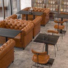 an empty restaurant with leather couches and tables