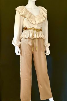 "STUNNING vintage C1970s high end, off white or ivory sumptuous long sleeve silk blouse by Partique, featuring a lavish V neck collar with pleated ruffles fully edged in gold trim, a peplum hem, also with pleated ruffles fully edged in gold trim, and a three button front closure.  Channeling Old Hollywood elegance and glamour, this rare beauty is a guaranteed head turner! Approximate Measurements:      Chest: 38\"; Shoulder: 16\"; Waist: 27\"; Length: 19 1/2\"      Labeled a Size 6 Please Note: V Neck Collar, Party Blouse, White Plains, American Fashion Designers, First Ladies, Womens Trousers, Ivory Silk, Rare Beauty, Peplum Hem