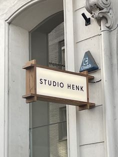 a sign hanging from the side of a building that says studio henk on it