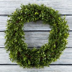 a green wreath sitting on top of a wooden table