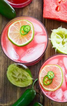 two glasses filled with watermelon and limeade on top of a wooden table