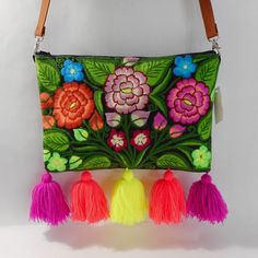 an embroidered purse with tassels and flowers on it