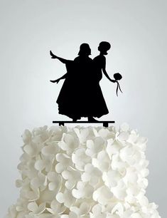 a cake topper that has a silhouette of two people on the top of it