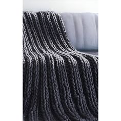 a gray blanket sitting on top of a white couch