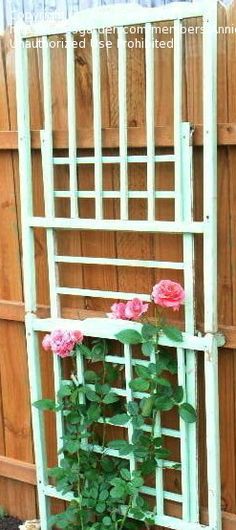 a potted plant with pink flowers in it next to a wooden trellis and fence