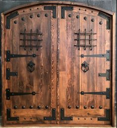 a large wooden door with metal hardware on the sides and side panels that are made out of wood