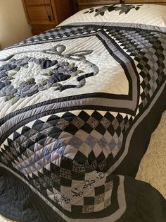 a bed with a black and white quilt on it