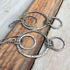 two metal rings are sitting on a piece of wood