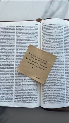 an open book with a piece of paper attached to it