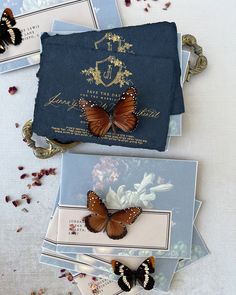 two butterflies sitting on top of some cards