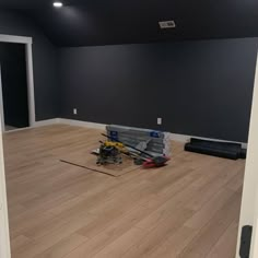 an empty room with hard wood flooring and construction tools on the ground in front of it