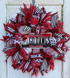 a red and black wreath with the word go dawgs on it is hanging on a door