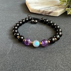 Introducing our Evil Eye Unisex Bracelet, a powerful accessory designed to provide empath protection and ward off negative energy. Handmade with a combination of Labradorite, Amethyst, and Black Tourmaline crystals, this adjustable bracelet offers a stylish and versatile design suitable for any wrist size.  * Labradorite, known for its mystical properties, enhances intuition and deflects unwanted energies. Amethyst promotes calmness and spiritual growth, while Black Tourmaline acts as a protecti Black Gemstone Beaded Bracelets For Meditation, Black Crystal Gemstone Bracelet For Meditation, Black Spiritual Gemstone Beaded Bracelets, Black Amethyst 8mm Bead Bracelets, Black Spiritual Bracelets With Natural Stones, Black Amethyst Bracelets With 8mm Beads, Black Amethyst Bracelet With 8mm Beads, Black Amethyst 8mm Bead Jewelry, Black Amethyst Beads Jewelry 8mm