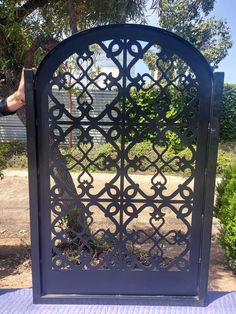 an iron gate is shown in front of some bushes