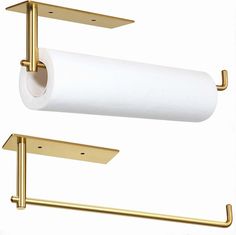 two gold toilet paper holders and a roll of toilet paper hanging from the wall next to each other