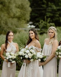 the bridesmaids are all wearing different styles of dresses and holding bouquets in their hands