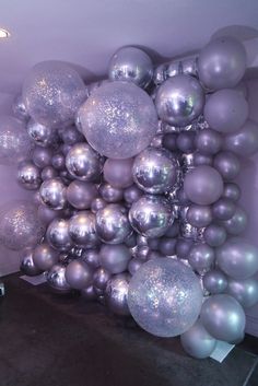 a room filled with lots of shiny silver balloons