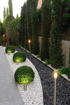 an outdoor garden with gravel and lights