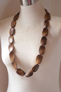 "One long strand of dark brown wood beads with glass spacer beads. The length is 37.5\" and the beads measure 1.5\" by 1\". The necklace length can be customized. The mannequin's neck size is 15\". The clasp is lead free pewter toggle. We do not recommend double wrapping this necklace. If you would like a multi strand version or other colors: www.etsy.com/shop/DanaLeBlancDesigns?ref=seller-platform-mcnav&search_query=miranda+wood All DLD jewelry comes in a silver jewelry box for gift giving. Adjustable Single Strand Brown Beads, Brown Wooden Beads For Jewelry Making, Adjustable Brown Beaded Necklaces With Oval Beads, Brown Long Beaded Necklace With Wooden Beads, Long Brown Beaded Necklace With Wooden Beads, Brown Wooden Beads Oval Jewelry, Brown Wooden Oval Beads Jewelry, Brown Jewelry With Oval Wooden Beads, Earthy Polished Brown Beads