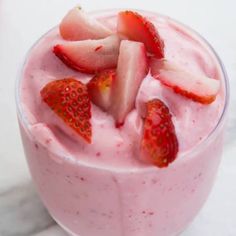 a smoothie topped with strawberries in a glass