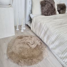 a dog bed is on the floor next to a white dresser and nightstand with candles