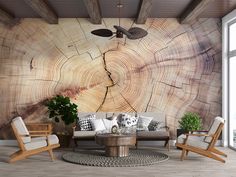 the living room is decorated in wood and has white chairs, a round coffee table, and a large tree trunk wall mural