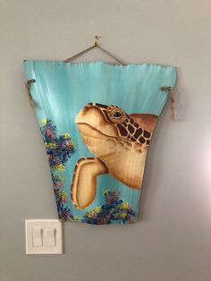 a painting of a sea turtle hanging on a wall next to a light switch box