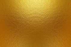 an abstract gold background with some light shining on it