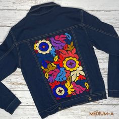 Soft and stretchable denim jacket with embroidery detail on back and upper bust area. Hand embridered Jalapa pattern y artisan women. 4 frontal pockets, waist length with metal buttons. Runs small Material:67% Cotton20% Polyester11% Rayon2% Spandex SIZE CHART: DENIM JACKET BUST LENGTH MEDIUM 32" 20" LARGE 34" 21" X-LARGE 36" 22" 2X-LARGE 41" 23" approximate measurements are in inches CARE: • Hand wash in cold water • Hang dry• Do not machine wash or dry. • Iron on low Embroidered Dark Wash Outerwear With Long Sleeves, Casual Denim Jacket With Multicolor Embroidery And Pockets, Dark Wash Embroidered Long Sleeve Outerwear, Dark Wash Long Sleeve Embroidered Outerwear, Fitted Cotton Outerwear With Multicolor Embroidery, Casual Fall Outerwear With Geometric Embroidery, Fitted Denim Jacket With Multicolor Embroidery, Cotton Outerwear With Geometric Embroidery For Fall, Fitted Multicolor Embroidered Outerwear With Pockets