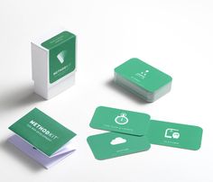 green business cards with white envelopes sitting next to each other