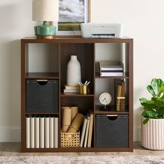 a bookshelf with many different items on top of it and a lamp next to it