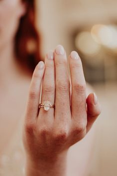 a close up of a person's hand holding a ring