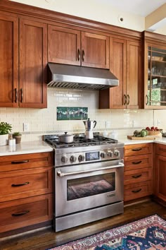 a stove top oven sitting inside of a kitchen next to wooden cabinets and counter tops