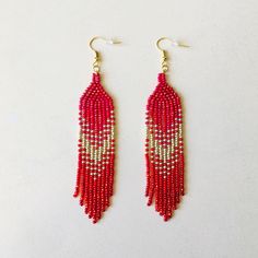 Shine bright these winter holidays wearing these long red beaded earrings with fringe. Inspired by tribal style, these statement waterfall earrings are made from high-quality Czech seed beads and supplied with stainless steel accessories. No doubt, these iridescent seed bead earrings will sparkle with every move. This pair will be a luxury addition to your Christmas look as well as a unique gift for bohemian jewelry lovers. 100% top-quality handmade earrings. Materials:  - 4 colors of Czech beads - gold color accessories. Length: 4,5'' / 11,43 cm Width: 0.8'' / 2 cm The real color of the item may be slightly different from the picture shown on website caused by the brightness of your monitor. If you have special size requirements, please send me a letter about it, as this can be made to or Elegant Red Beaded Earrings For Festival, Red Dangle Tassel Earrings For Festive Occasions, Red Tassel Earrings For Festivals, Red Dangle Tassel Earrings With Fringe, Red Tassel Earrings With Fringe And Round Beads, Red Fringe Tassel Earrings With Round Beads, Red Fringe Tassel Earrings As Gift, Red Tassel Earrings With Round Beads As Gift, Red Tassel Earrings With Fringe For Gift