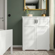 a white cabinet and mirror in a room