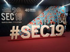 people are standing in front of a sign that says secc19 on it and there is a red carpet