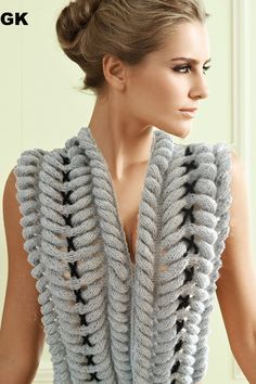 a woman wearing a gray knitted vest with black stars on the front and back