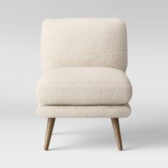 an upholstered white chair with wooden legs