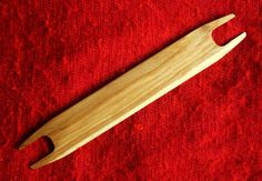 a wooden knife is laying on a red cloth