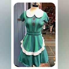 a green and white dress is displayed on a mannequin