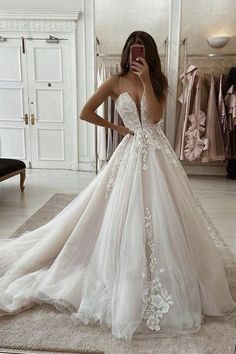 a woman taking a selfie while wearing a wedding dress in front of a mirror