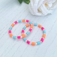 Light Blue, Hot Pink & orange Acrylic & Clay Bead Bracelet  ❋ Listing is for one Acrylic and Clay Bead Bracelet with an Elastic Cord  ❋ Clear Acrylic Beads  ❋ Light Blue, Hot Pink and Orange Clay Beads  ❋ One Size fits most  ❋ Colors may vary due to lighting  ☆ Perfect to stack with our VIP Era Acrylic and Clay Bead Bracelet  ❤️Care Tips❤️  ❋ Best to keep away from water and direct sunlight   ❋ Material can be fragile if dropped or if band is stretched   ❋ Please roll on Bracelets   ❋ Do not pul Orange Beach Bracelets With Spacer Beads, Orange Beaded Heishi Bracelets, Orange Bangle Bracelet With Colorful Beads, Adjustable Coral Stretch Bracelet, Orange Heishi Beads Bracelets For Beach, Coral Beaded Adjustable Bracelets, Hand-strung Orange Bracelets For Beach, Adjustable Beaded Coral Bracelet, Orange Bead Bracelets For Beach