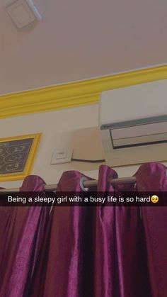 there is a purple curtain in front of the air conditioner on the wall above it