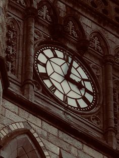 a large clock on the side of a building with roman numerals and windows