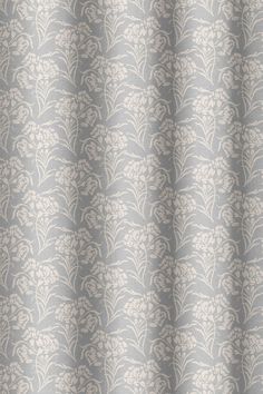 a gray and white curtain with leaves on it