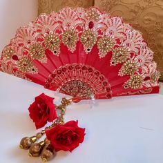 Wedding elegant and stunning Bridal hand held decorative luxurious red  fan ,bride ,mehndi ,maiyon, haldi wedding day shaadi walima accessory . Fixed open decorative fan hand embellished with crystals , ,beads ,acrylic decorative details ,hand embroidery  french knots and crystal encasing. Bejewelled with Zari golden flowers enhanced with teardrop diamanté . Handmade zari embellished organza  form the faux rose droplets which will hang as the fan is held.  These are exclusively made items and therefore will not be produced in large repetitive form making your wedding accessory unique. Taffeta silk cotton  woven fan base  ,printed and embossed and decorated with a medley of crystals  ,beads and finished with a sprinkle of glitter ,in hues of red and gold dimensions approx 41 cm x 46cm drop Red Kundan Tikka For Navratri, Red Tikka For Navratri, Red Traditional Tikka For Diwali, Traditional Red Tikka For Diwali, Traditional Red Tikka As Gift, Red Tikka For Diwali, Red Bollywood Tikka For Navratri, Red Tilla Dupatta For Diwali, Bollywood Style Festive Bridal Accessories